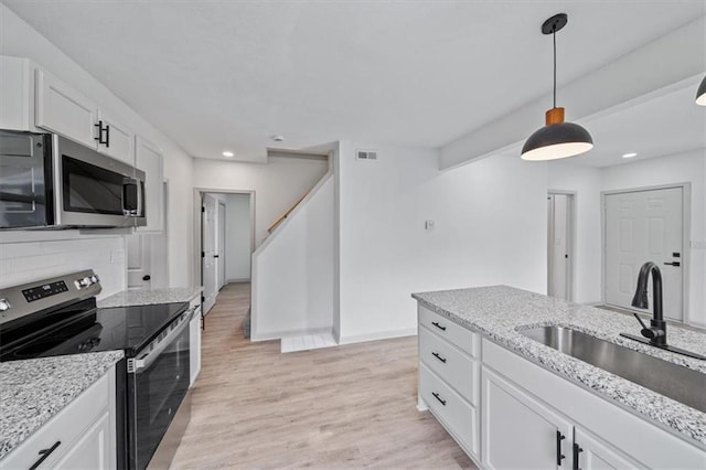 1514 N 25th St, Kansas City, KS 66102 - kitchen featuring stainless steel appliances, a sink, white cabinets, recessed lighting, and light stone counters