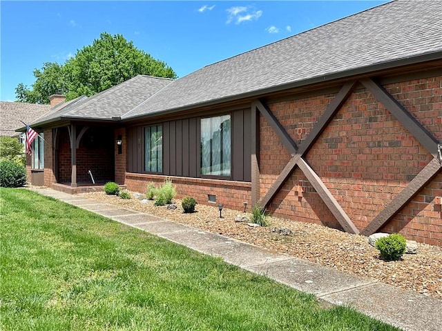 917 Country Club Dr, Butler, MO 64730 - view of home's exterior with roof with shingles, brick siding, a lawn, and board and batten siding