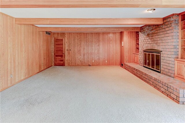 917 Country Club Dr, Butler, MO 64730 - unfurnished living room featuring beam ceiling, carpet, a fireplace, and wood walls