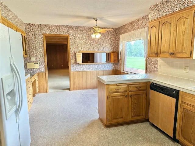 917 Country Club Dr, Butler, MO 64730 - kitchen with white refrigerator with ice dispenser, dishwasher, wallpapered walls, tile counters, and a peninsula