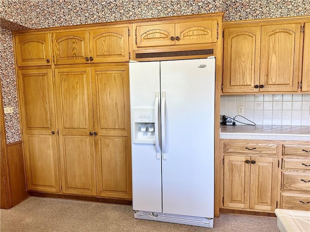 917 Country Club Dr, Butler, MO 64730 - kitchen featuring white refrigerator with ice dispenser, tile counters, and decorative backsplash