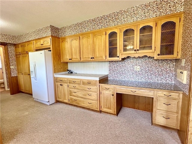 917 Country Club Dr, Butler, MO 64730 - kitchen featuring white refrigerator with ice dispenser, a textured ceiling, light colored carpet, and glass insert cabinets