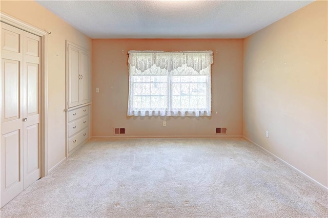 917 Country Club Dr, Butler, MO 64730 - unfurnished bedroom featuring light colored carpet and a textured ceiling