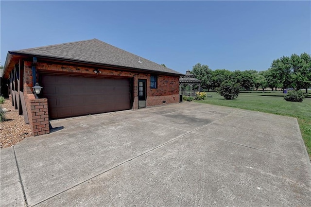 917 Country Club Dr, Butler, MO 64730 - view of home's exterior with a shingled roof, a yard, driveway, an attached garage, and brick siding
