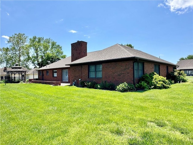 917 Country Club Dr, Butler, MO 64730 - rear view of house featuring a chimney, a yard, brick siding, and a shingled roof