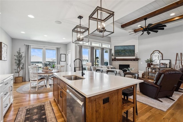 1108 NE Goshen Ct, Lees Summit, MO 64064 - kitchen featuring stainless steel dishwasher, a sink, a brick fireplace, light wood finished floors, and beam ceiling
