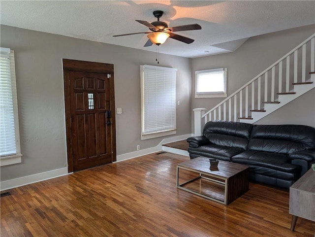 117 W N St, Warrensburg, MO 64093 - living area with wood finished floors, a ceiling fan, baseboards, a textured ceiling, and stairs