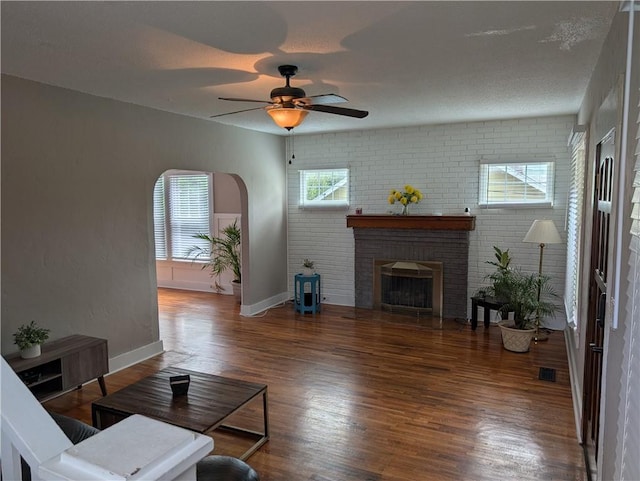 117 W N St, Warrensburg, MO 64093 - living room with wood finished floors, a ceiling fan, a brick fireplace, and baseboards