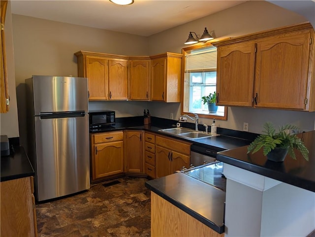 117 W N St, Warrensburg, MO 64093 - kitchen featuring stainless steel appliances, a sink, dark countertops, and stone finish floors