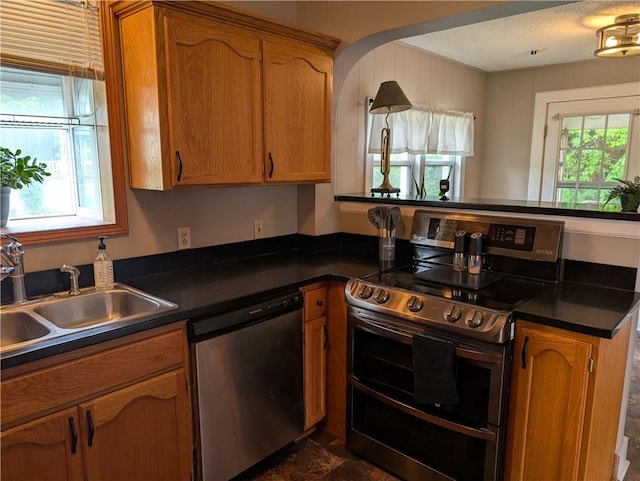 117 W N St, Warrensburg, MO 64093 - kitchen featuring appliances with stainless steel finishes, a sink, dark countertops, and healthy amount of natural light