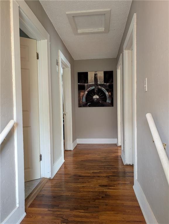 117 W N St, Warrensburg, MO 64093 - corridor with wood finished floors, attic access, baseboards, and a textured ceiling