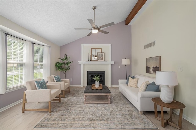 7243 Rene St, Shawnee, KS 66216 - living area with ceiling fan, a tiled fireplace, healthy amount of natural light, baseboards, and a textured ceiling