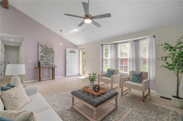 7243 Rene St, Shawnee, KS 66216 - living area featuring wood finished floors, a textured ceiling, healthy amount of natural light, a ceiling fan, and high vaulted ceiling