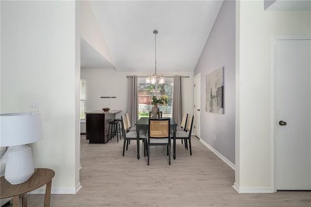 7243 Rene St, Shawnee, KS 66216 - dining area featuring a chandelier, vaulted ceiling, light wood finished floors, and baseboards