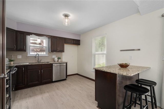 7243 Rene St, Shawnee, KS 66216 - kitchen with appliances with stainless steel finishes, a sink, a peninsula, a breakfast bar area, and dark brown cabinets