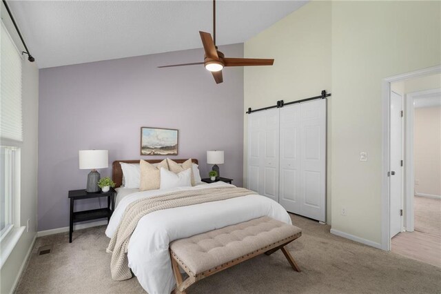 7243 Rene St, Shawnee, KS 66216 - bedroom with a barn door, light colored carpet, high vaulted ceiling, and baseboards