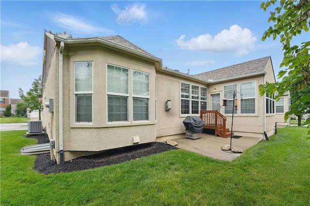 22480 W 113th St, Olathe, KS 66061 - back of property featuring a lawn, stucco siding, central AC, and a patio area