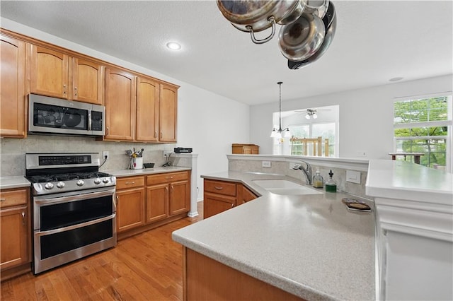 22480 W 113th St, Olathe, KS 66061 - kitchen featuring stainless steel appliances, a sink, light wood-type flooring, light countertops, and tasteful backsplash