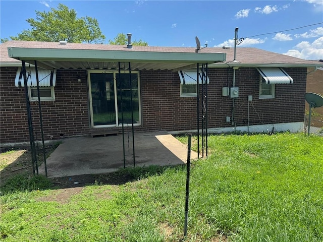 8724 N Jefferson St, Kansas City, MO 64155 - rear view of house with brick siding, a patio area, and a yard