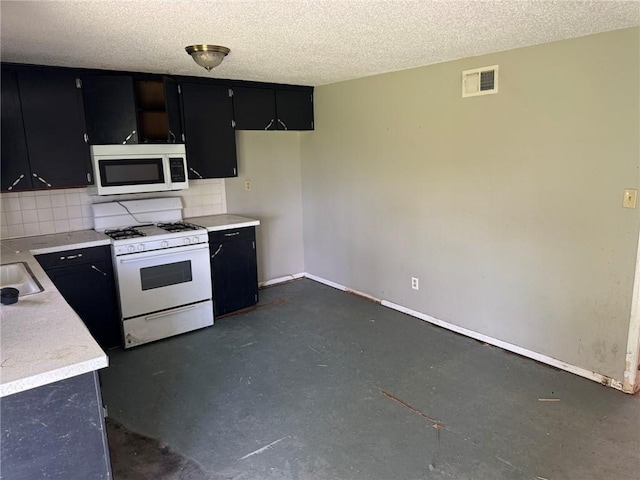 8724 N Jefferson St, Kansas City, MO 64155 - kitchen featuring white appliances, dark cabinetry, backsplash, light countertops, and a textured ceiling