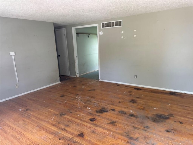 8724 N Jefferson St, Kansas City, MO 64155 - unfurnished room featuring wood-type flooring, a textured ceiling, and baseboards