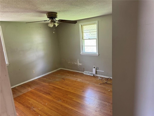 8724 N Jefferson St, Kansas City, MO 64155 - empty room with wood finished floors, a ceiling fan, a textured ceiling, and baseboards