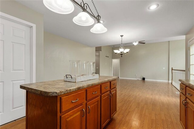 3208 Arbor Lake Dr, Saint Joseph, MO 64506 - kitchen with a chandelier, a center island, hanging light fixtures, light wood-type flooring, and brown cabinets