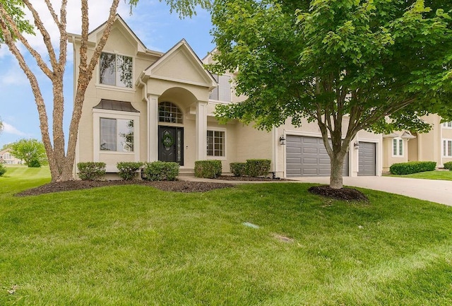 1410 Cross Creek Dr, Raymore, MO 64083 - traditional home featuring concrete driveway, stucco siding, and a front yard