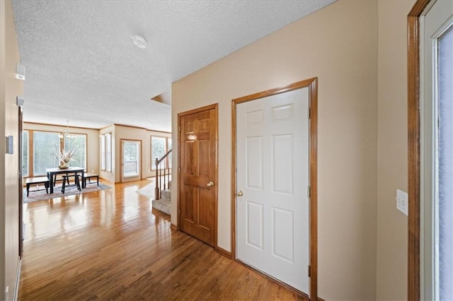 14801 W 70th St, Shawnee, KS 66216 - corridor featuring wood finished floors, a textured ceiling, stairway, and baseboards