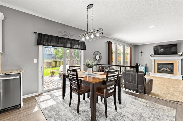 9820 N Donnelly Ave, Kansas City, MO 64157 - dining room featuring ornamental molding, wood finished floors, a textured ceiling, a tile fireplace, and baseboards