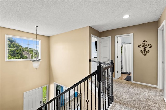 9820 N Donnelly Ave, Kansas City, MO 64157 - corridor featuring an upstairs landing, a textured ceiling, light colored carpet, and baseboards