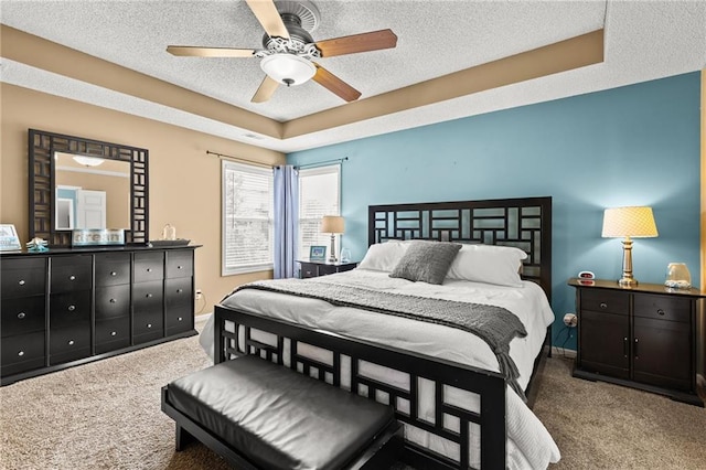 9820 N Donnelly Ave, Kansas City, MO 64157 - carpeted bedroom featuring a textured ceiling, a raised ceiling, and ceiling fan