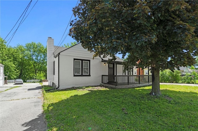 2317 S Maywood Ave, Independence, MO 64052 - view of front of home featuring a chimney, a front yard, brick siding, and driveway