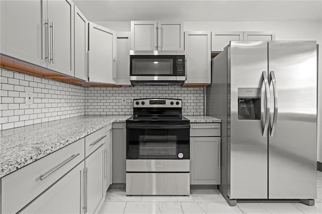 2317 S Maywood Ave, Independence, MO 64052 - kitchen featuring stainless steel appliances, light marble finish flooring, light stone counters, and tasteful backsplash
