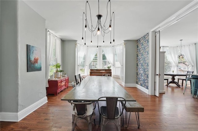 906 E Piankishaw St, Paola, KS 66071 - dining area featuring baseboards, dark wood-style flooring, and a chandelier