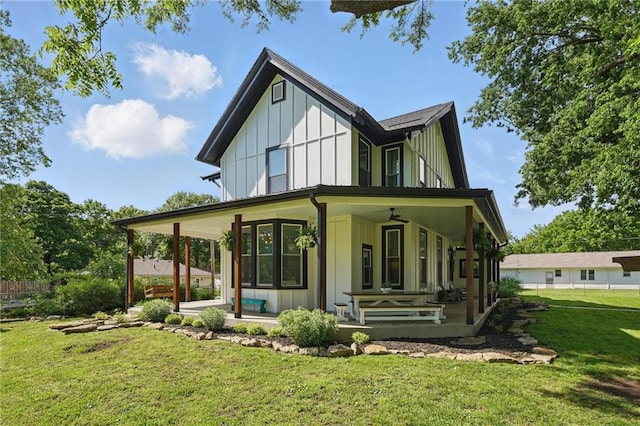 906 E Piankishaw St, Paola, KS 66071 - view of front of house with board and batten siding, covered porch, and a front lawn