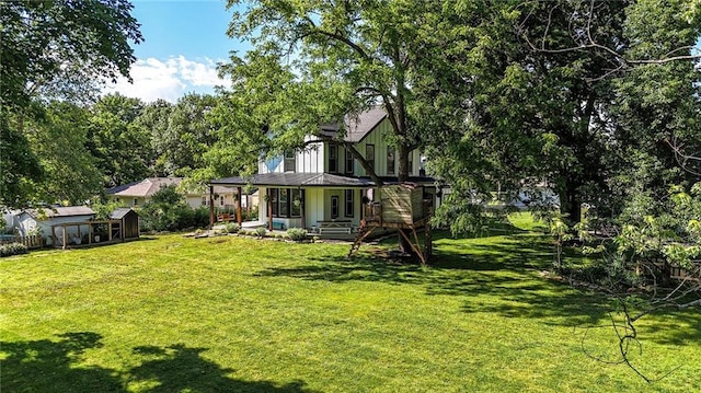 906 E Piankishaw St, Paola, KS 66071 - rear view of property featuring a yard and an outbuilding