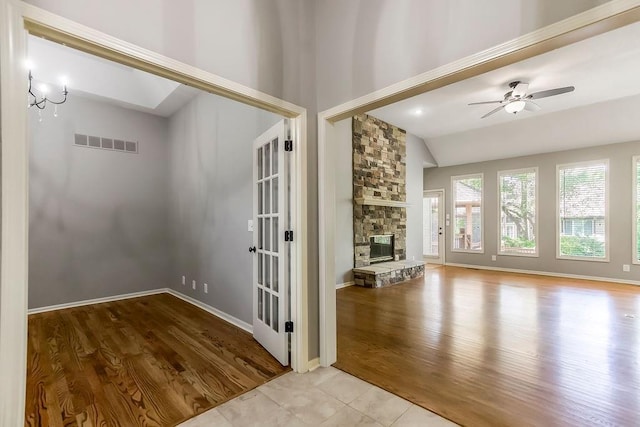 5408 W 153rd St, Leawood, KS 66224 - unfurnished living room featuring wood finished floors, vaulted ceiling, ceiling fan, a fireplace, and french doors