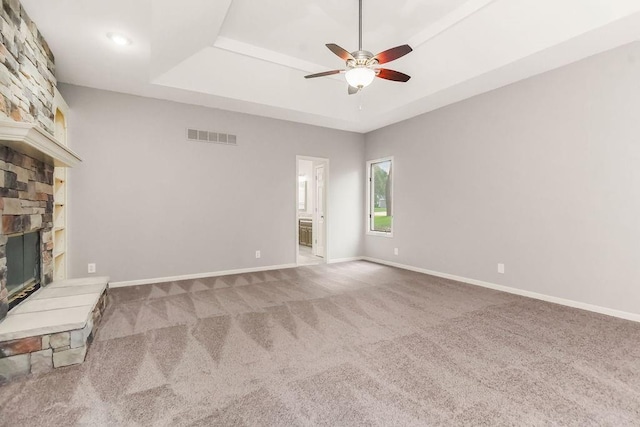5408 W 153rd St, Leawood, KS 66224 - unfurnished living room featuring a tray ceiling, ceiling fan, a stone fireplace, carpet, and baseboards