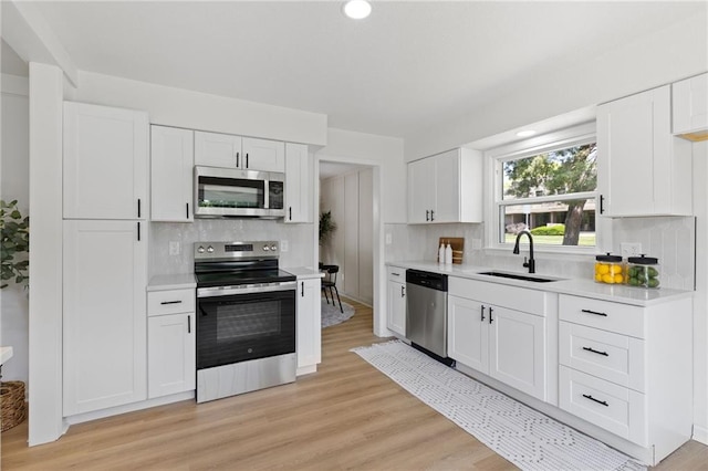 9501 Glenwood St, Overland Park, KS 66212 - kitchen featuring stainless steel appliances, a sink, tasteful backsplash, light countertops, and white cabinets