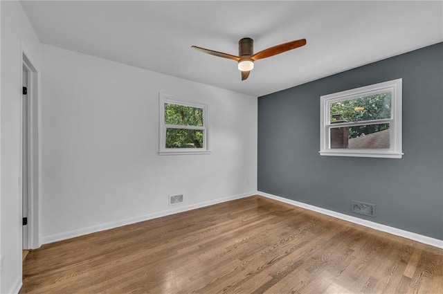 5005 S Grand Ave, Independence, MO 64055 - empty room featuring healthy amount of natural light, ceiling fan, wood finished floors, and baseboards