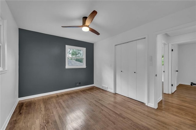 5005 S Grand Ave, Independence, MO 64055 - unfurnished bedroom with wood finished floors, baseboards, and a closet