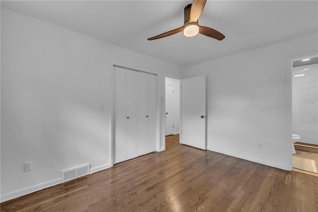 5005 S Grand Ave, Independence, MO 64055 - unfurnished bedroom with wood finished floors, ensuite bath, a closet, baseboards, and ceiling fan