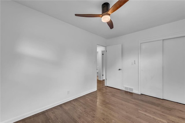 5005 S Grand Ave, Independence, MO 64055 - unfurnished bedroom with wood finished floors, baseboards, a closet, and ceiling fan