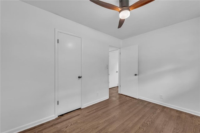5005 S Grand Ave, Independence, MO 64055 - unfurnished bedroom featuring wood finished floors, baseboards, and ceiling fan