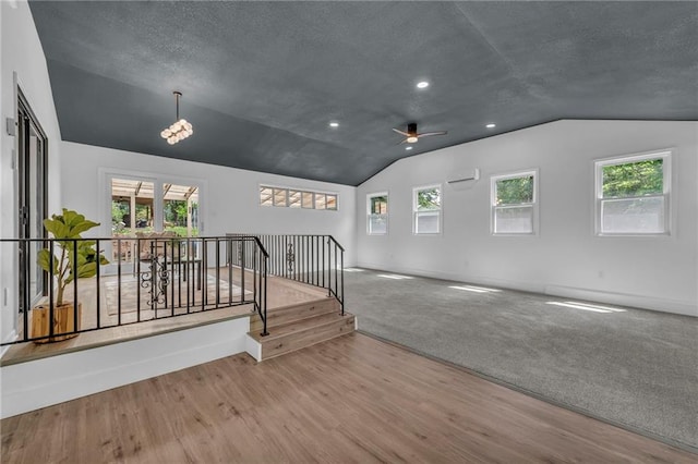 5005 S Grand Ave, Independence, MO 64055 - unfurnished living room with vaulted ceiling, a ceiling fan, wood finished floors, baseboards, and healthy amount of natural light