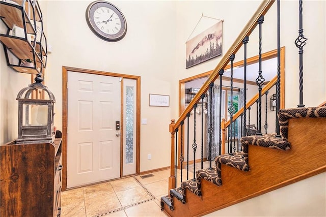 7504 N Palmer Ave, Kansas City, MO 64158 - entryway with stairway, a high ceiling, light tile patterned floors, and baseboards