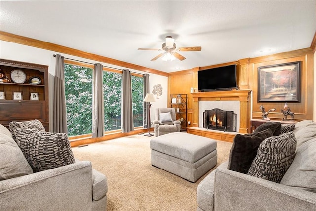7504 N Palmer Ave, Kansas City, MO 64158 - living area featuring a ceiling fan, crown molding, carpet flooring, and a lit fireplace