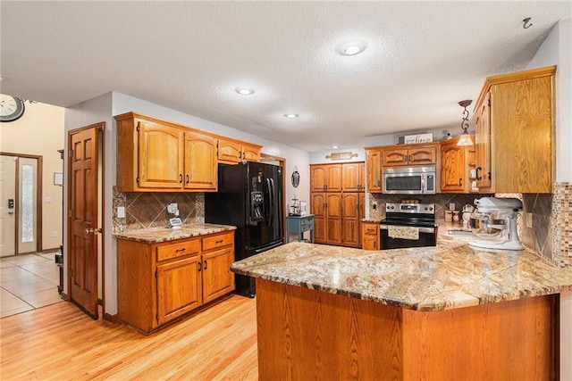 7504 N Palmer Ave, Kansas City, MO 64158 - kitchen with appliances with stainless steel finishes, a peninsula, brown cabinets, tasteful backsplash, and light wood-type flooring