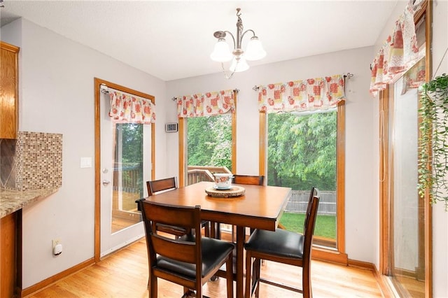 7504 N Palmer Ave, Kansas City, MO 64158 - dining area featuring a chandelier, light wood-style floors, and baseboards